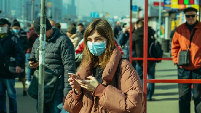 KYIV, UKRAINE - March 19. 2020. Quarantine in the city of Kiev due to the COVID-19 virus. People are standing at public transport stops in protective masks against the virus.