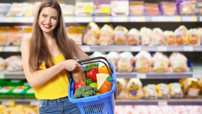 Young woman with basket shopping in supermarket