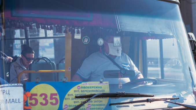 KYIV, UKRAINE - March 19. 2020. Quarantine in the city of Kiev due to the COVID-19 virus. Minibus driver in a protective mask against the virus.