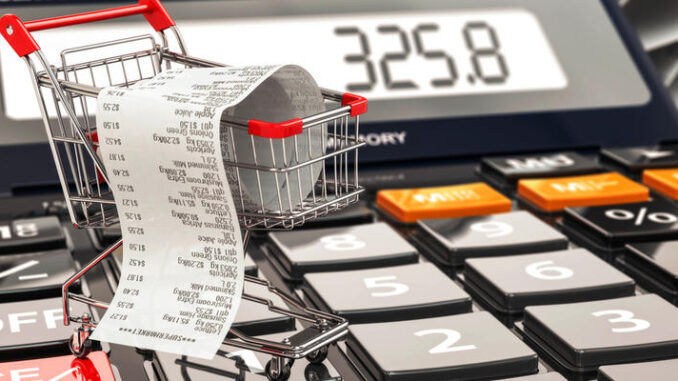 Shopping cart on calculator and receipt. Home budget or consumer
