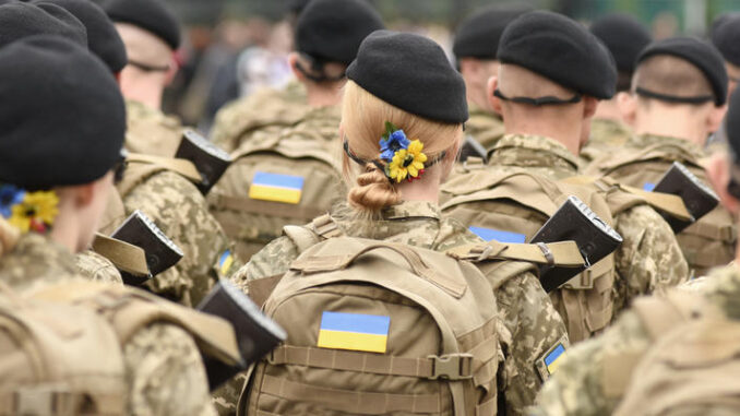Woman soldier. Woman in army. Ukrainian flag on military uniform