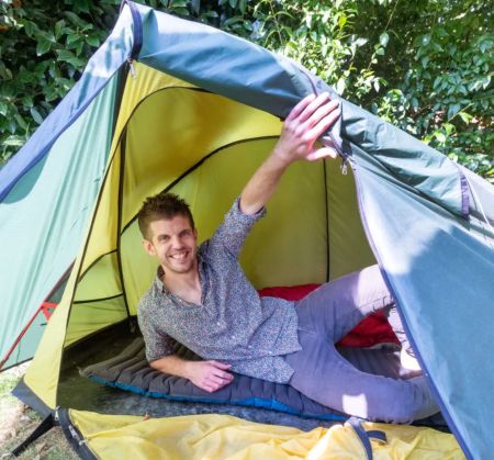 Чоловік спить у наметі в саду, щоб нормально уникнути стресу від виховання дітей